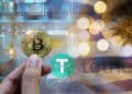mano sosteniendo moneda de bitcoin con mineros asic en el fondo junto a bandera de Uruguay y logo de tether
