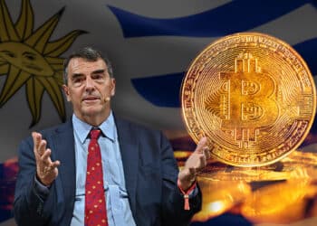 Tim Draper junto a moneda de bitcoin con bandera de Uruguay en el fondo