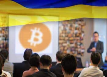 personas viendo clases sobre bitcoin en sala de conferencias con bandera de ucrania superpuesta