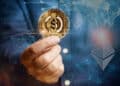 mano sosteniendo moneda de USDC con logo de ethereum en red digital