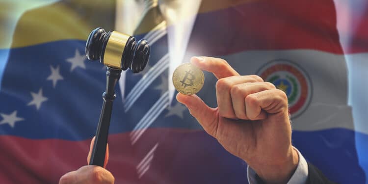 hombre sostiene moneda de bitcoin junto a martillo de juez con banderas de Venezuena y Paraguay en el fondo