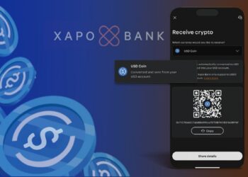 monedas de USDC cayendo junto a telefono movil con opción de USDC seleccionada con lofo de Xapo bank en el fondo