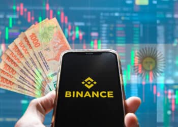 Binance, pesos argentinos y bandera de Argentina.