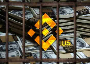 logo de Binance US sobre billetes de dolares apilados detrás de rejas