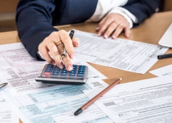 mujer calculando impuestos sobre escritorio