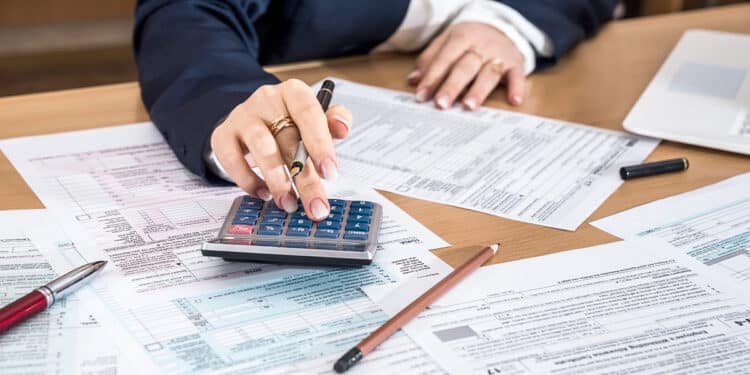 mujer calculando impuestos sobre escritorio