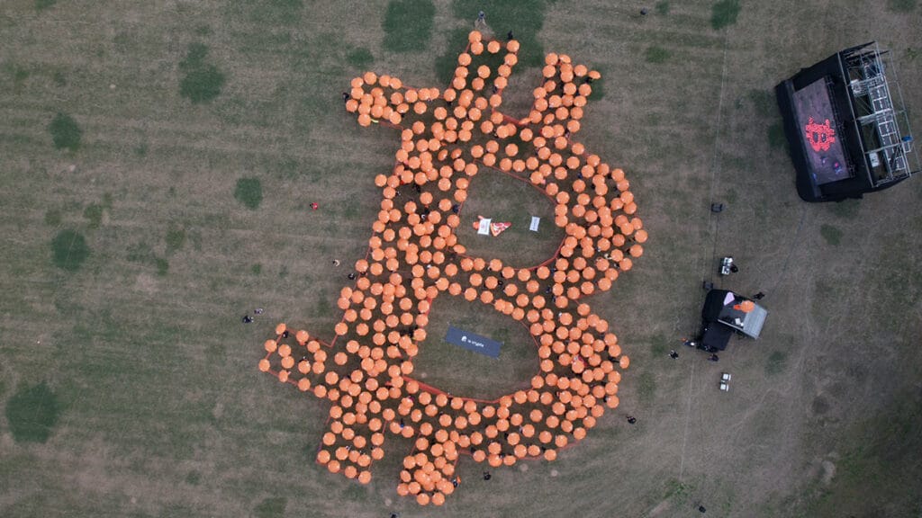 Vista aérea de Paraguas naranjas formando una gran B de Bitcoin.