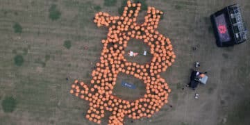 Vista aérea de Paraguas naranjas formando una gran B de Bitcoin.