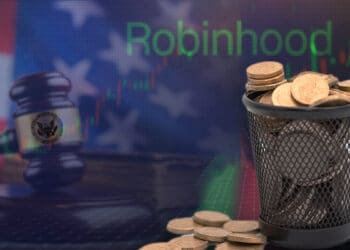 monedas dentro de basurero sobre plataforma de exchane con logo de robinhood y martillo de juez sobre escritorio con bandera de estados unidos en el fondo