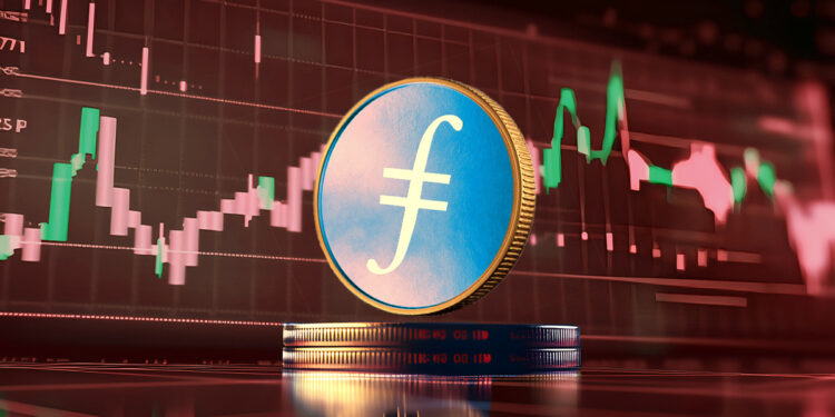 moneda de filecoin sobre monedas apiladas con grafico de precio cayendo en el fondo