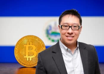 Mow y bitcoin con bandera de El Salvador de fondo.