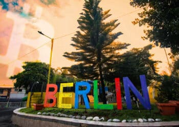 plaza de la ciudad de Berlín con logo de bitcoin en el cielo