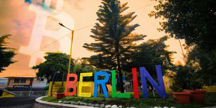 plaza de la ciudad de Berlín con logo de bitcoin en el cielo
