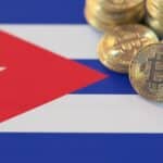 Monedas de bitcoin físicas están sobre una bandera de Cuba