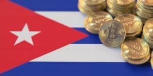 Monedas de bitcoin fรญsicas estรกn sobre una bandera de Cuba