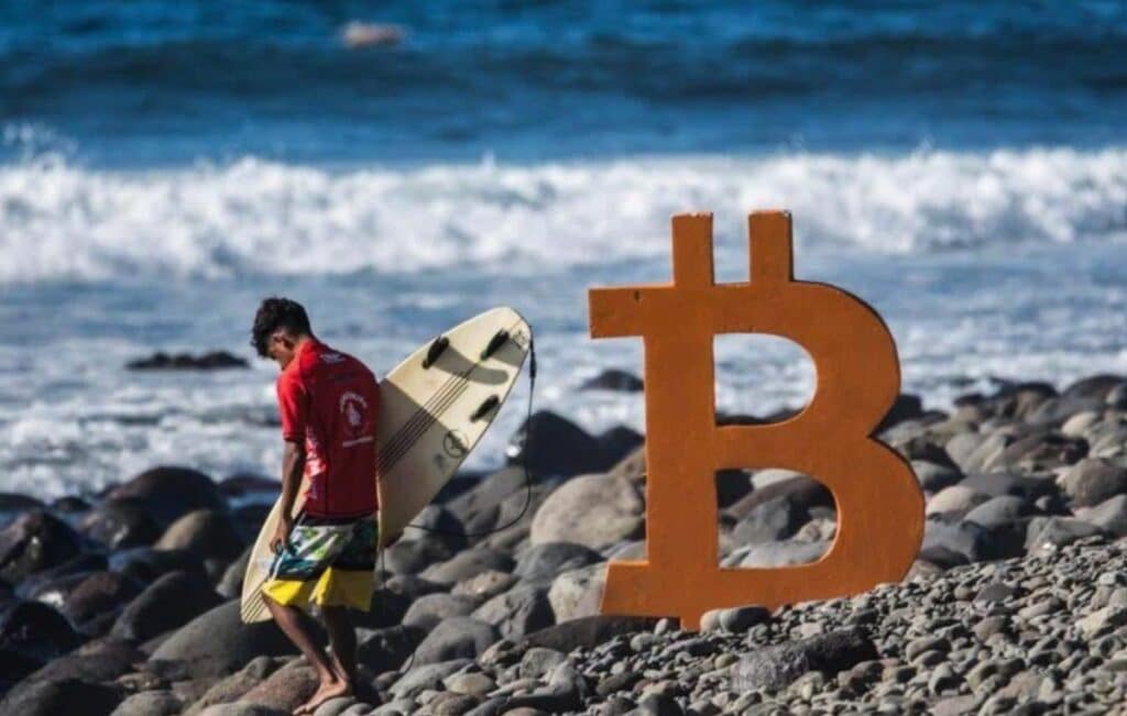 surfista en la playa bitcoin beach