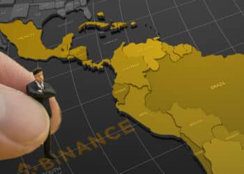 mano colocando figura de perosona en mapa de latinioamerica con logo de binance