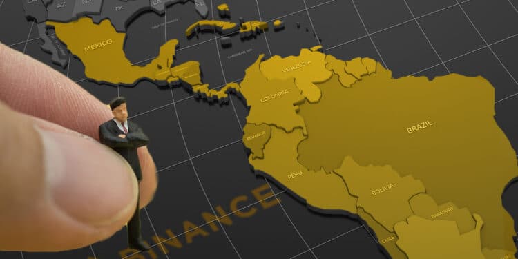 mano colocando figura de perosona en mapa de latinioamerica con logo de binance