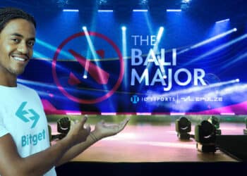 hombre con logo de Bitget en camiseta presentando escenario con logo de The Bali Major en el escenario