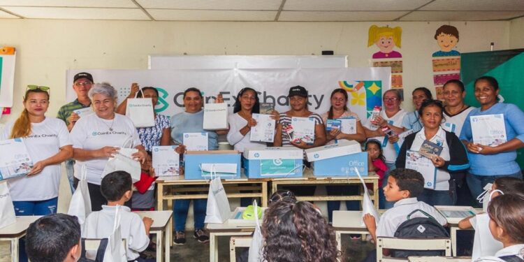 Salon de clases con maestros al frente y niños sentados en pupitres.