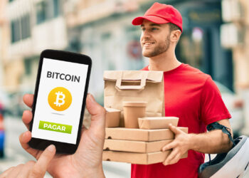 Delivery y persona pagando con bitcoin.