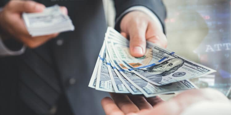 persona con logo de Bitfinex en traje entregando billetes de dolares