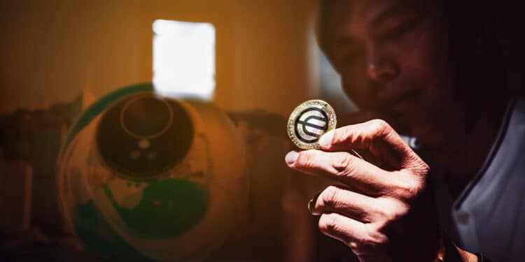 hombre sostiene moneda de world coin
