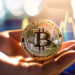 mano sosteniendo moneda de bitcoin con grafico de precio al alza en el fondo