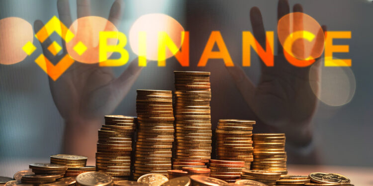 monedas apiladas sobre mesa con logo de binance en vidrio y persona detrás