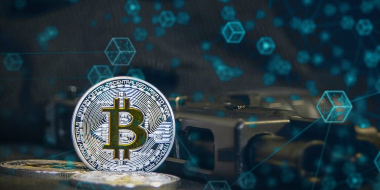 moneda de bitcoin junto a arma de guego con red de bloques digitales superpuesta