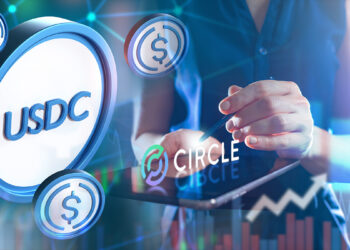 monedas de usdc junto a persona señlando logo de Circle sobre pantalla