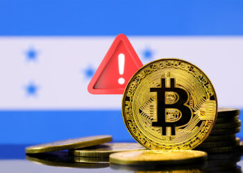 Bitcoin, bandera de Honduras y símbolo de alerta.