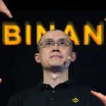 manos seรฑalando a Changpeng Zhao, CEO de Binance con logo de la empresa detrรกs