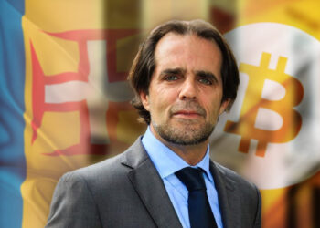 Miguel Albuquerque con banderas de Madeira y Bitcoin en el fondo