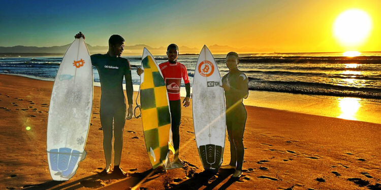 niños africanos en playa con tablas de surf con calcomanías de Bitcoin