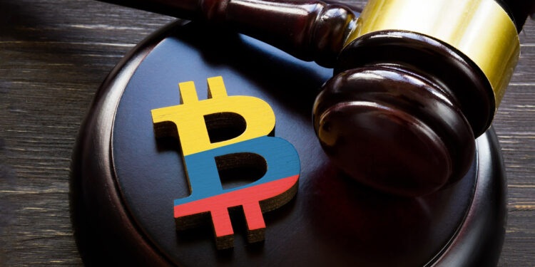 Martillo de ley y bitcoin con bandera de Colombia.