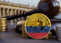 moneda de bitcoin con bandera de colombia pintada entre monedas y martillo de juez, con edificio del Congreso de colombia en el fondo