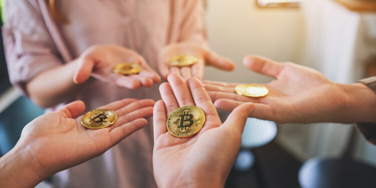 manos sosteniendo monedas de bitcoin