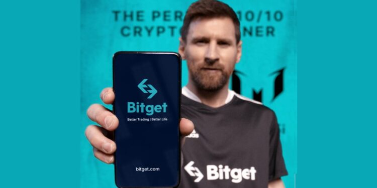 Imagen de Leonel Messi sosteniendo un celular con el logo de Bitget en pantalla.
