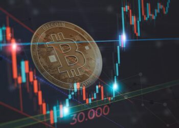 moneda de bitcoin entre grafico de precio en bajada alcanzando soporte a nivel de 30.000 dólares y regresando al alza