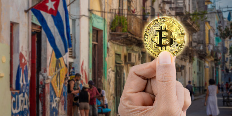 mano sosteniendo moneda de bitcoin con paisaje de Cuba en el fondo
