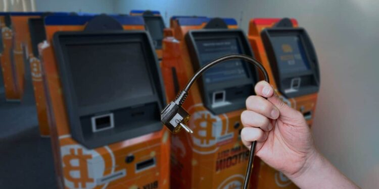 mano sosteniendo cable de poder desconectado de cajeros automaticos de bitcoin en panamá