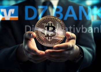 moneda de bitcoin sobre manos de empresario con logo de DZ Bank en el fondo