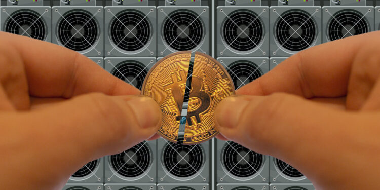 Manos masculinas sosteniendo una moneda de bitcoin partida en dos frente a equipos de minería.