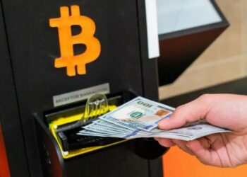 Persona introduciendo billetes en un cajero Bitcoin