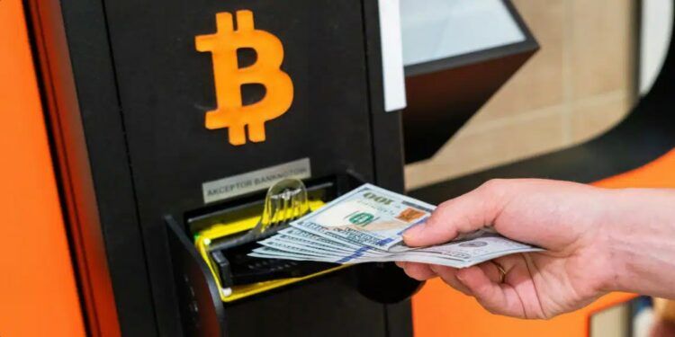 Persona introduciendo billetes en un cajero Bitcoin