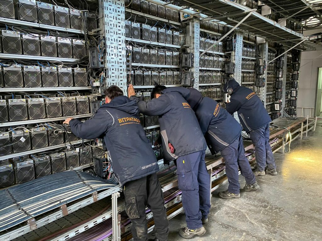 Empleados de Bitpatagonia haciendo mantenimiento de equipos ASIC