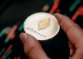 Una moneda de Ethereum sobre un gráfico de precios.