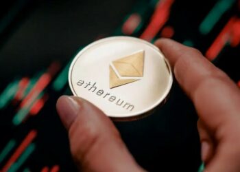 Una moneda de Ethereum sobre un gráfico de precios.