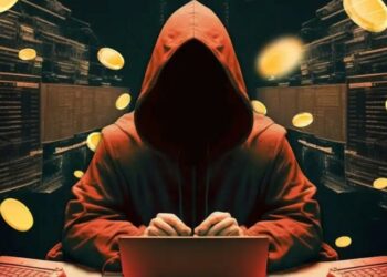 Hacker frente a una computadora y monedas en el aire rodeándolo